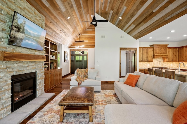 living room with recessed lighting, a stone fireplace, wood finished floors, built in features, and wood ceiling