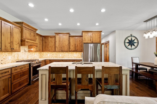 kitchen with stainless steel appliances, a sink, backsplash, a breakfast bar, and recessed lighting