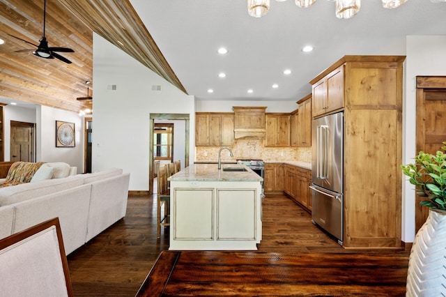 kitchen featuring stainless steel appliances, open floor plan, a sink, a ceiling fan, and vaulted ceiling