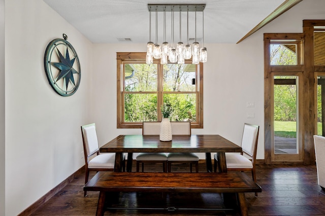 dining space featuring a chandelier, hardwood / wood-style flooring, and baseboards