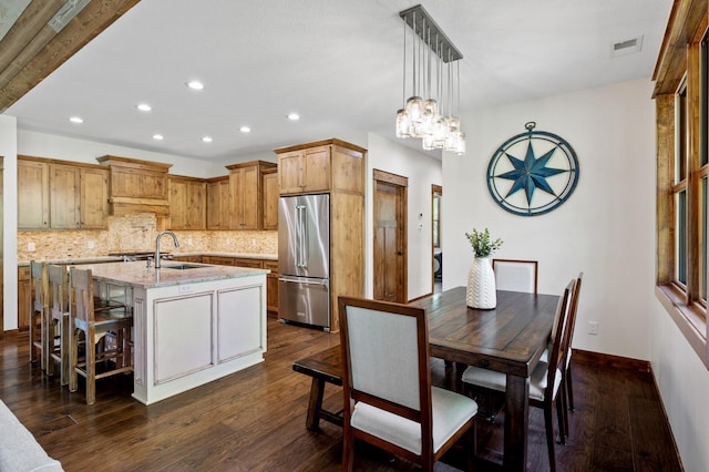 kitchen featuring high quality fridge, a sink, recessed lighting, tasteful backsplash, and dark wood finished floors