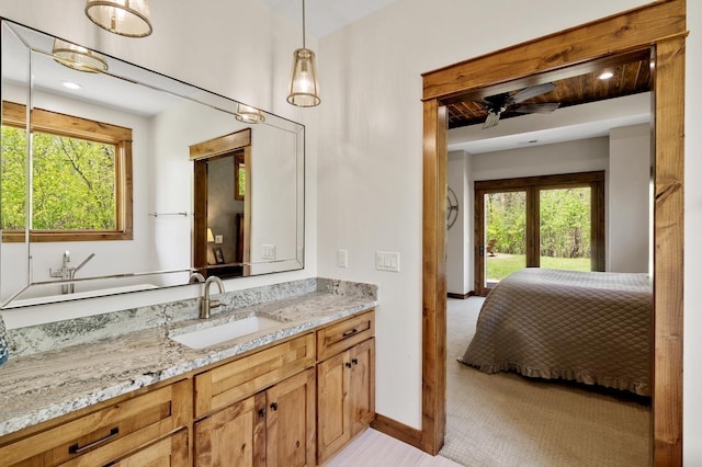 bathroom with plenty of natural light, vanity, a ceiling fan, and baseboards