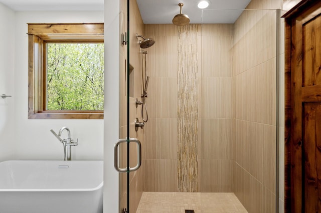 full bath featuring a stall shower and a soaking tub