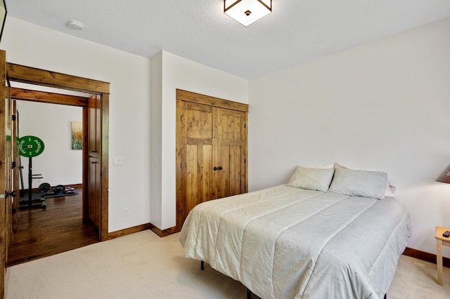 bedroom with baseboards, carpet floors, and a closet