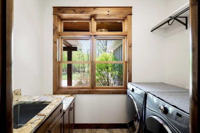 washroom with cabinet space, washing machine and clothes dryer, and baseboards