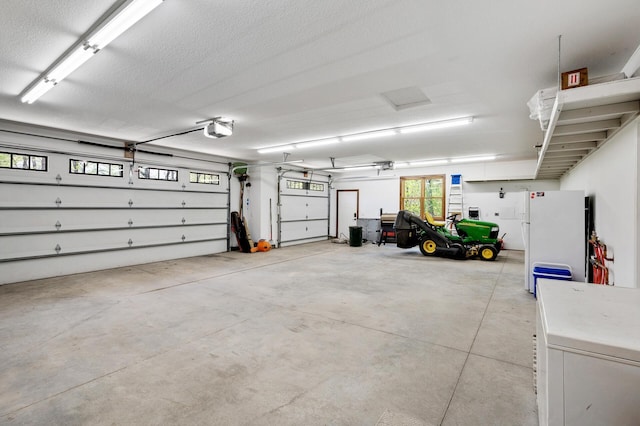garage with freestanding refrigerator, a garage door opener, and fridge