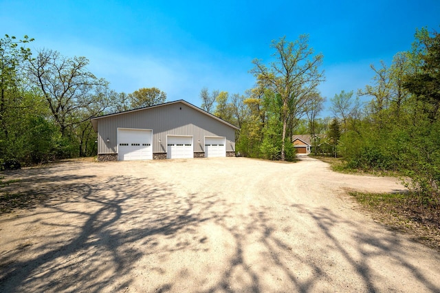 view of property exterior with a garage and an outbuilding