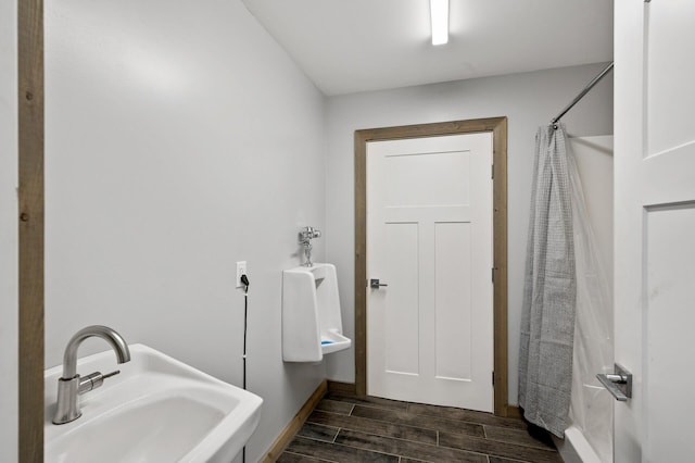 bathroom with a sink, wood finished floors, and baseboards