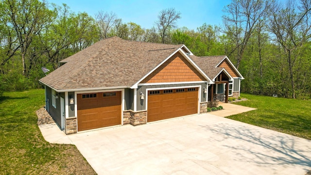 craftsman house with stone siding, a front lawn, a shingled roof, and concrete driveway