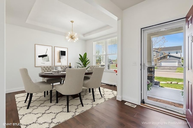 3618 112th Cir NE, Blaine, MN 55449 - dining space featuring a chandelier, plenty of natural light, a raised ceiling, and dark wood-style floors