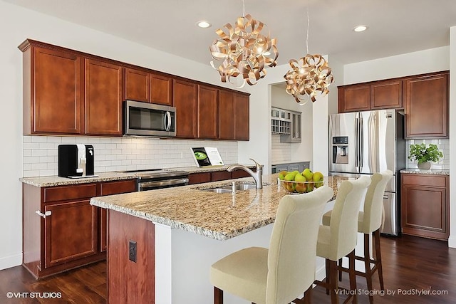 3618 112th Cir NE, Blaine, MN 55449 - kitchen featuring appliances with stainless steel finishes, a sink, dark wood-style flooring, tasteful backsplash, and light stone countertops
