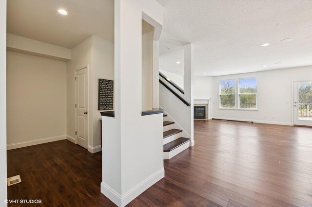 3618 112th Cir NE, Blaine, MN 55449 - stairway featuring wood finished floors, baseboards, a glass covered fireplace, and recessed lighting