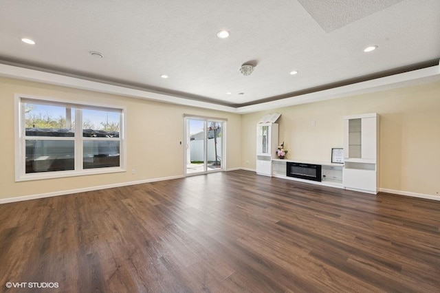 3618 112th Cir NE, Blaine, MN 55449 - unfurnished living room with dark wood-style floors, recessed lighting, baseboards, a glass covered fireplace, and a tray ceiling