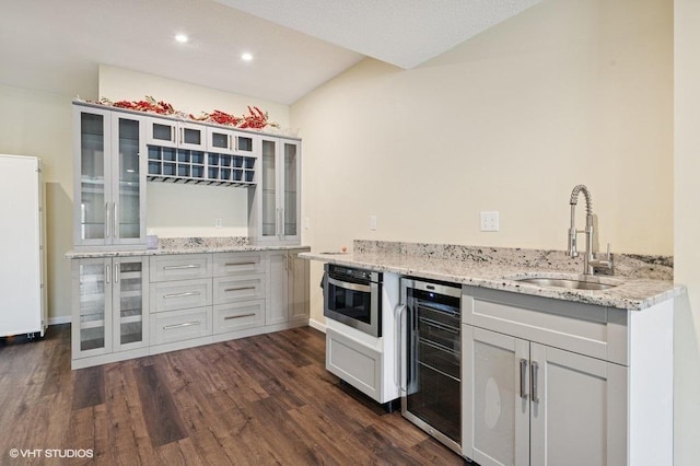 3618 112th Cir NE, Blaine, MN 55449 - indoor wet bar with beverage cooler, dark wood finished floors, vaulted ceiling, recessed lighting, and oven