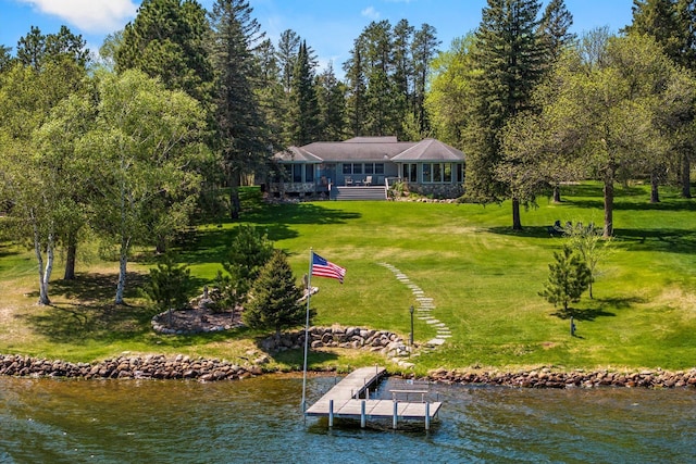 back of property with a yard and a water view