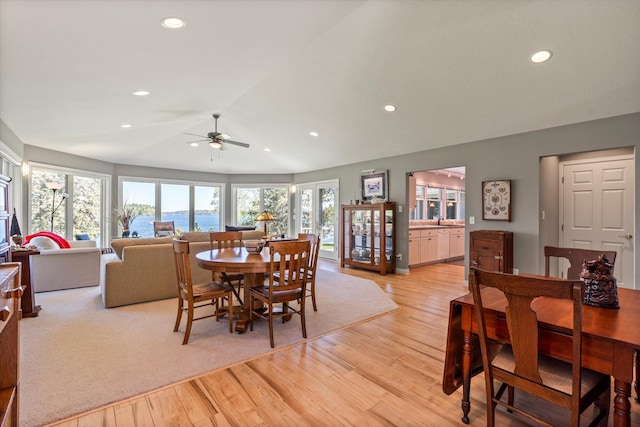 dining area with light wood-type flooring, a ceiling fan, lofted ceiling, healthy amount of natural light, and recessed lighting
