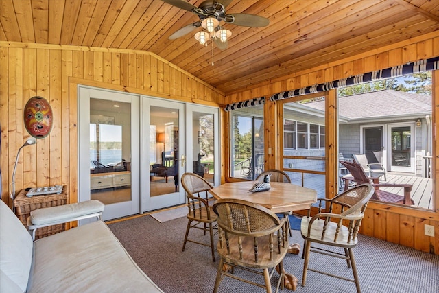 sunroom with french doors, vaulted ceiling, wood walls, plenty of natural light, and wood ceiling