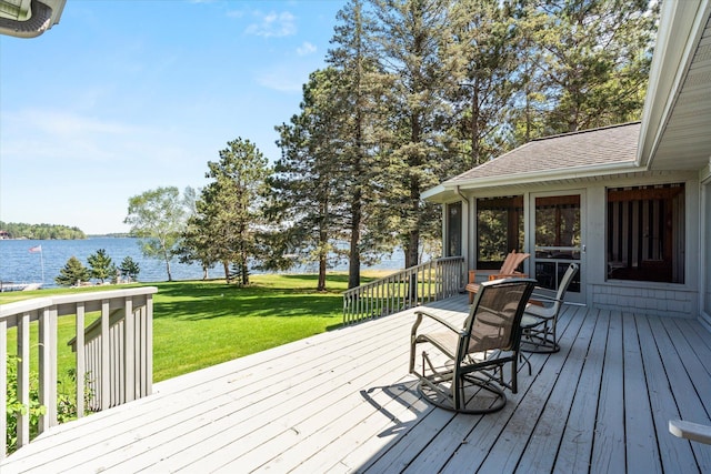 wooden terrace with a water view, a lawn, and a sunroom