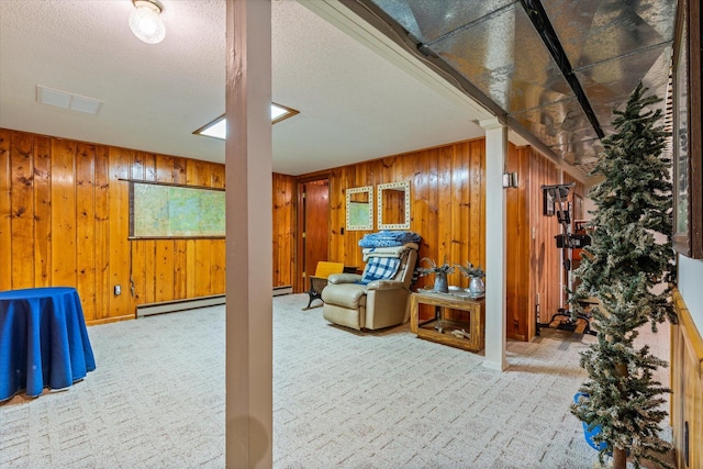 living area featuring carpet floors, a baseboard radiator, wood walls, a textured ceiling, and baseboards
