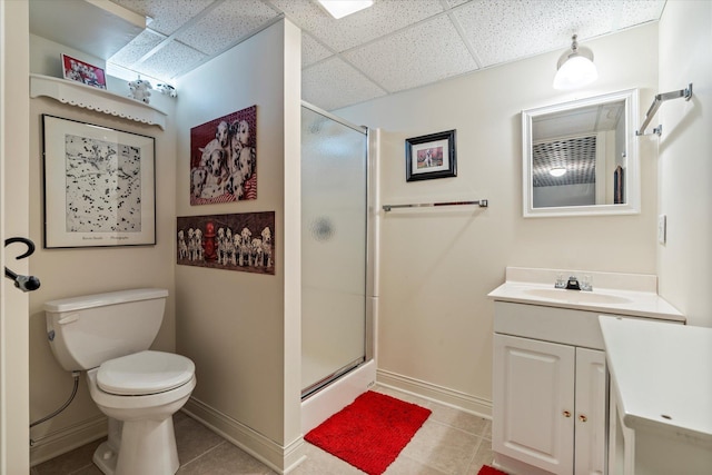 full bath with a paneled ceiling, a stall shower, baseboards, tile patterned floors, and toilet