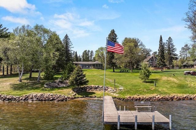 dock area with a lawn and a water view