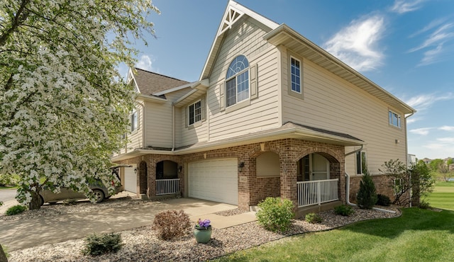 townhome / multi-family property featuring brick siding, an attached garage, concrete driveway, a front yard, and covered porch