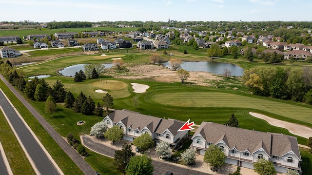 aerial view of property and surrounding area with a golf course, nearby suburban area, and a large body of water