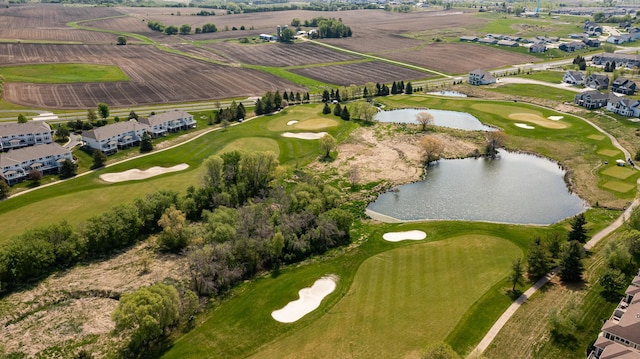 view of property location featuring a nearby body of water, a golf course, and nearby suburban area
