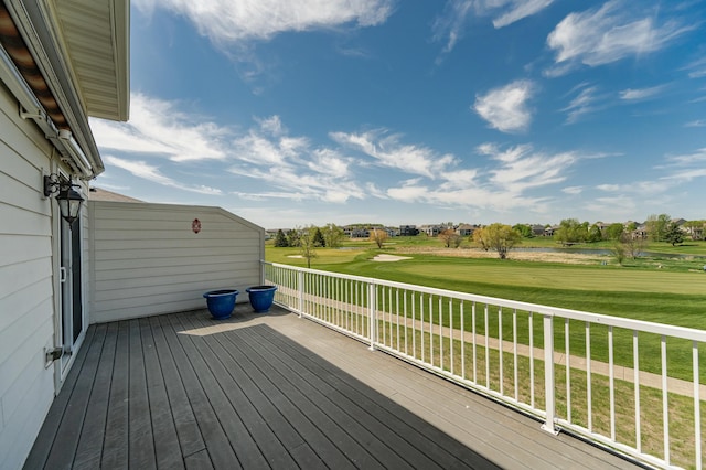 wooden terrace with golf course view and a yard