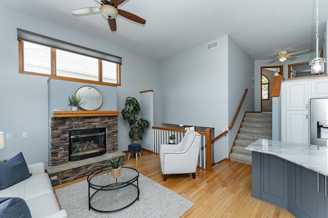 living room with ceiling fan, light wood finished floors, and plenty of natural light
