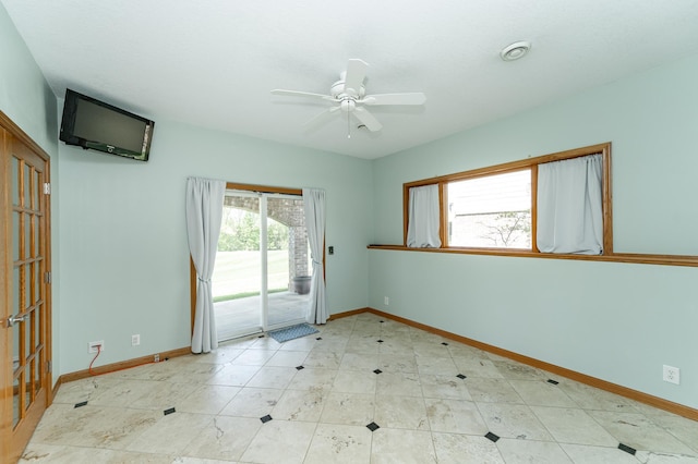unfurnished room featuring baseboards and ceiling fan