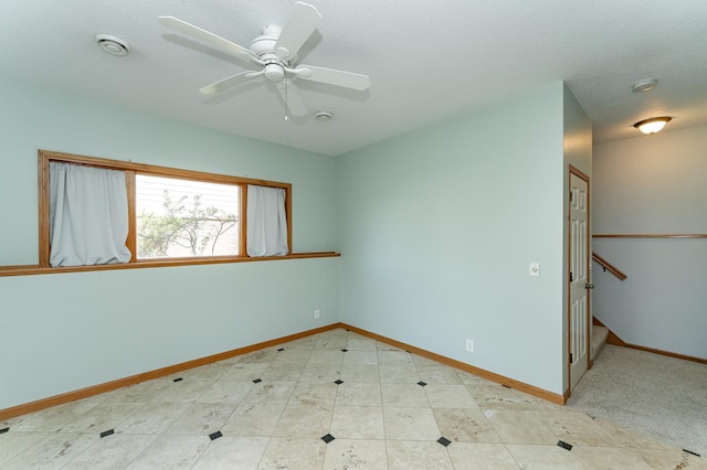 empty room featuring baseboards, a ceiling fan, and a smoke detector