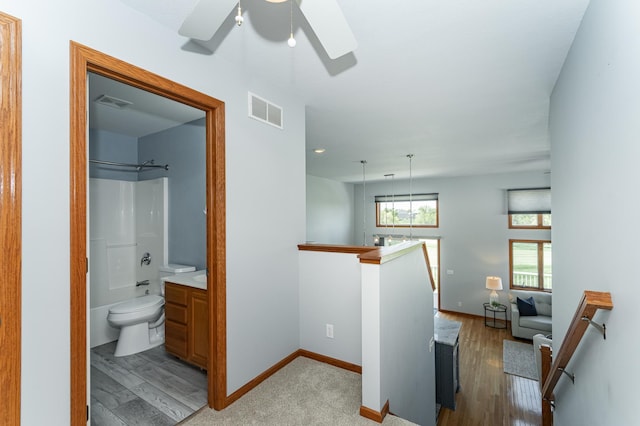 corridor with light wood-type flooring, baseboards, and an upstairs landing