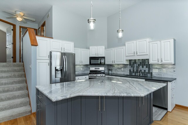 1463 Belvior Ln NE, Byron, MN 55920 - kitchen with appliances with stainless steel finishes, a sink, a towering ceiling, decorative backsplash, and white cabinets
