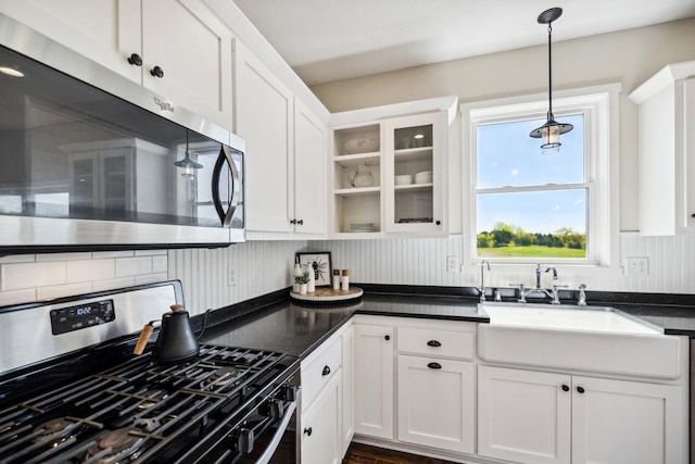 13985 120th St N, Stillwater Twp, MN 55082 - kitchen featuring appliances with stainless steel finishes, white cabinets, dark countertops, a sink, and decorative light fixtures