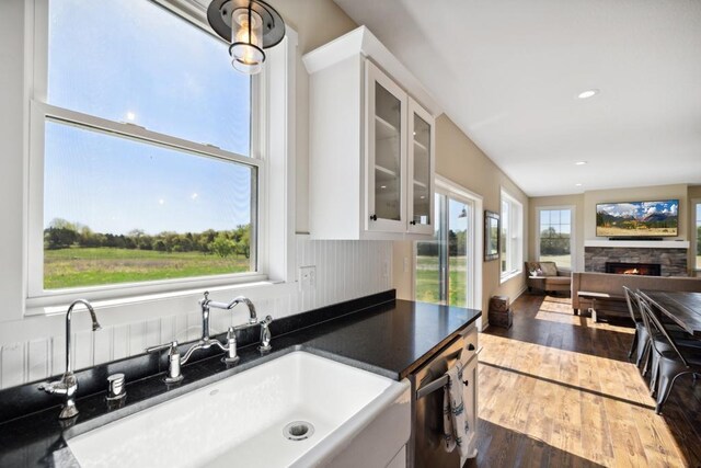 13985 120th St N, Stillwater Twp, MN 55082 - kitchen with a sink, dark countertops, hardwood / wood-style floors, white cabinets, and glass insert cabinets