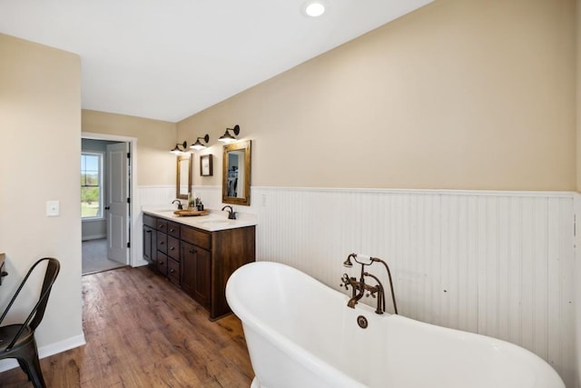 13985 120th St N, Stillwater Twp, MN 55082 - bathroom with a wainscoted wall, wood finished floors, double vanity, and a soaking tub