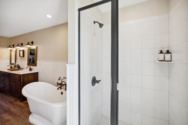 13985 120th St N, Stillwater Twp, MN 55082 - bathroom with a stall shower, a soaking tub, wainscoting, double vanity, and wood finished floors