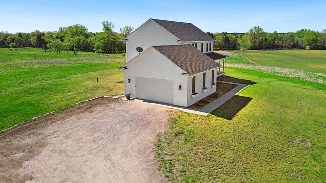 13985 120th St N, Stillwater Twp, MN 55082 - view of side of home with dirt driveway, a lawn, and a garage
