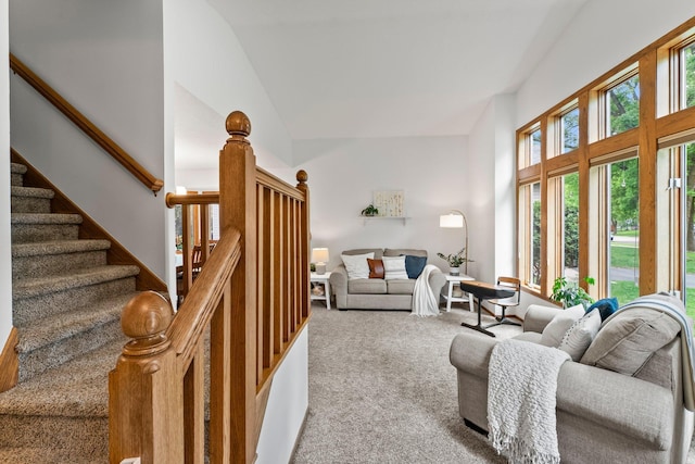 living room featuring carpet, high vaulted ceiling, and stairway