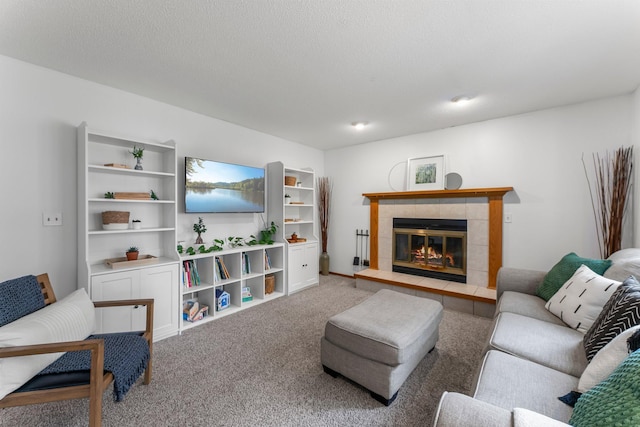 carpeted living room with a tile fireplace