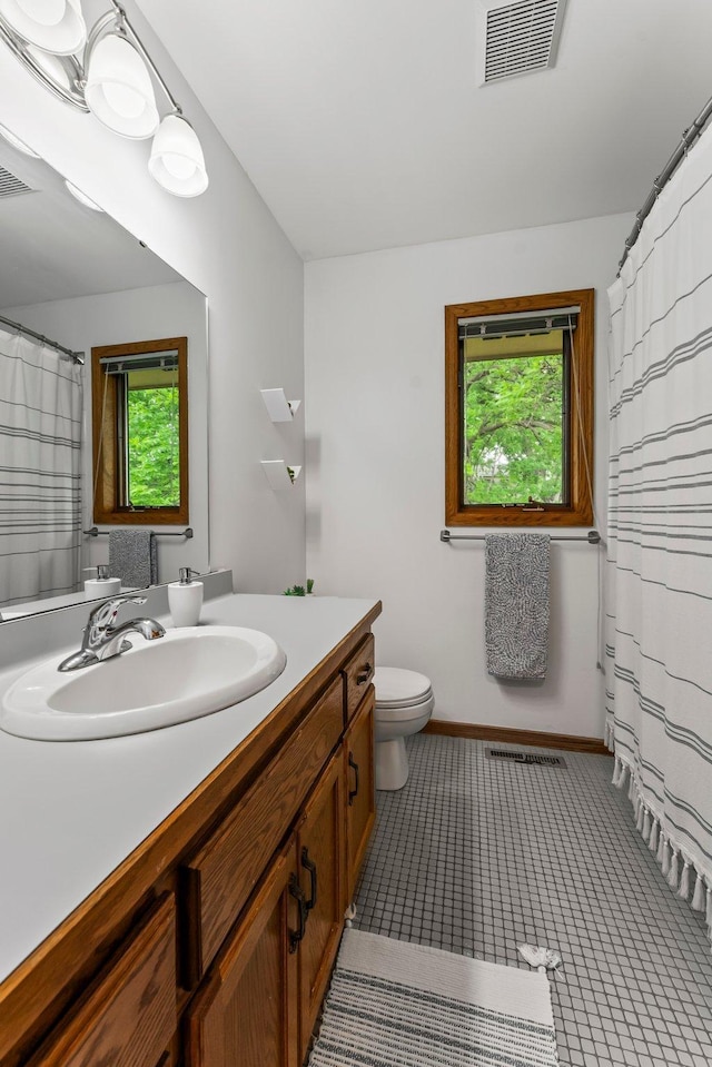 full bath with vanity, toilet, and tile patterned flooring