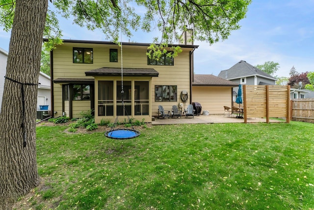 back of house with a patio area, a sunroom, and roof with shingles