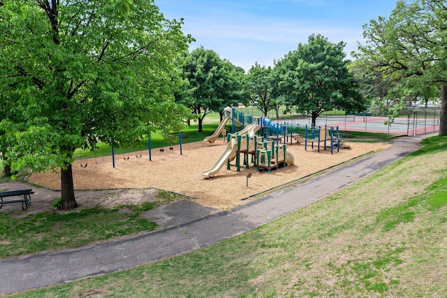 communal playground featuring a tennis court and fence