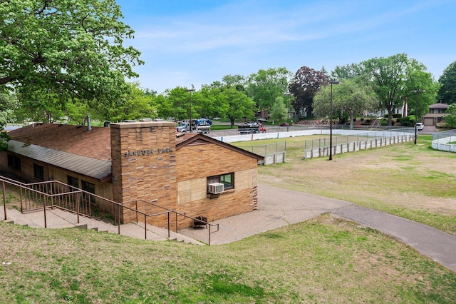 view of side of property featuring view of wooded area and a lawn