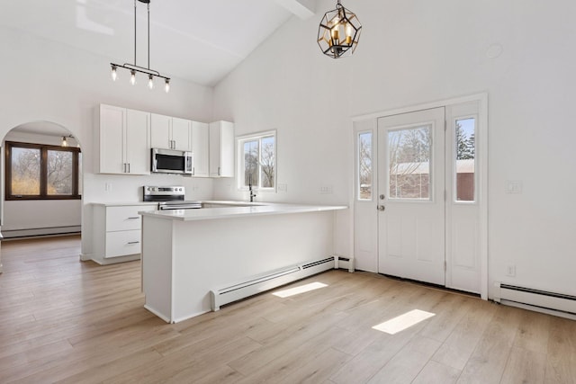 19835 County Road 30, Corcoran, MN 55340 - kitchen with stainless steel appliances, a baseboard heating unit, high vaulted ceiling, arched walkways, and light countertops