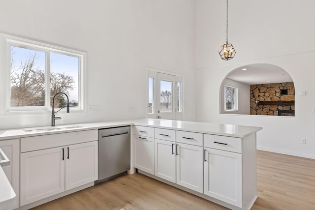 19835 County Road 30, Corcoran, MN 55340 - kitchen with a sink, stainless steel dishwasher, a peninsula, light wood finished floors, and light countertops