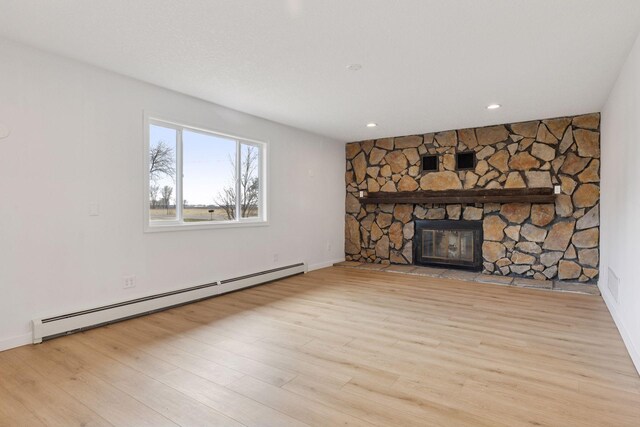 19835 County Road 30, Corcoran, MN 55340 - unfurnished living room featuring a baseboard heating unit, a fireplace, wood finished floors, baseboards, and recessed lighting