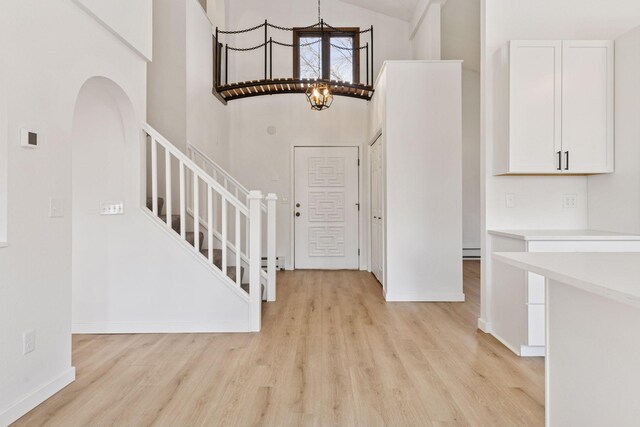 19835 County Road 30, Corcoran, MN 55340 - foyer featuring a high ceiling, light wood-type flooring, stairway, arched walkways, and baseboards