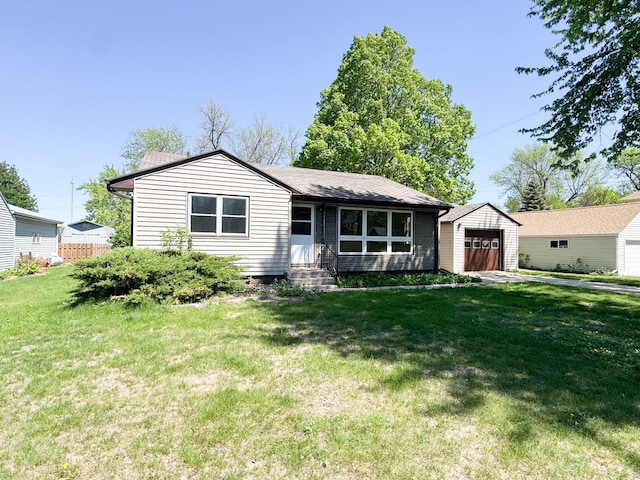 view of front facade with entry steps, a front lawn, an outdoor structure, and an attached garage